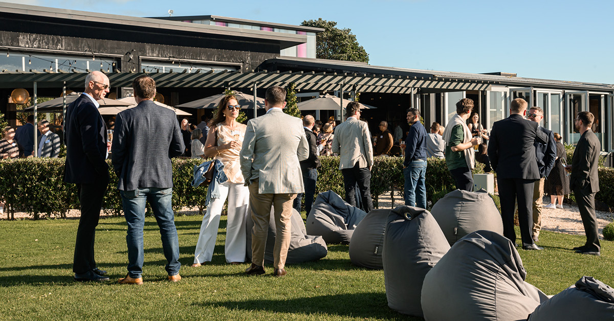 Corporate guests networking on the lawn at an outdoor Waiheke Island event venue